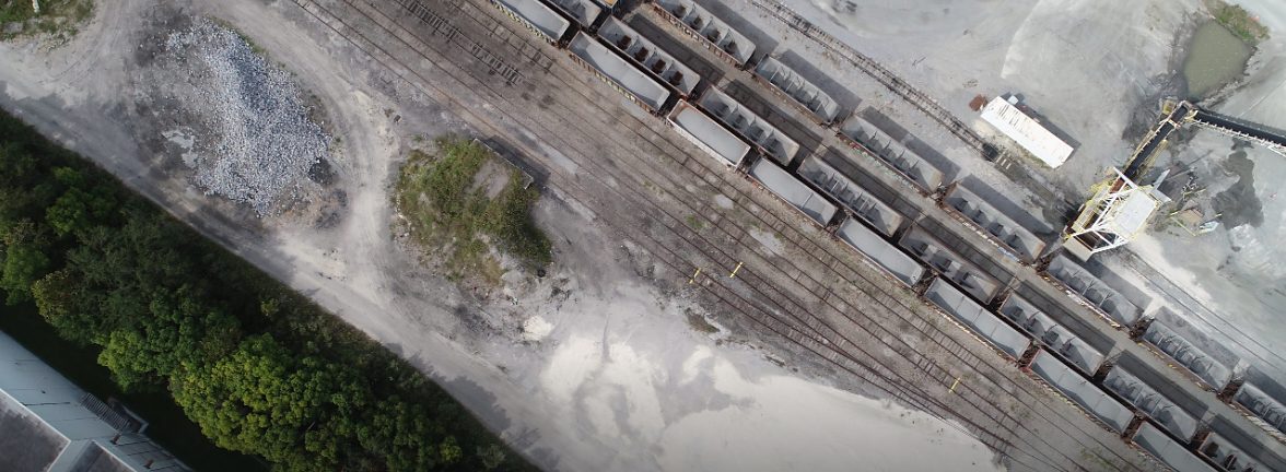 Aerial view of rail cars, material stockpiles and haul roads at an aggregate facility