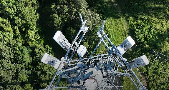 Aerial view looking down on a telecommunications tower surrounded by trees