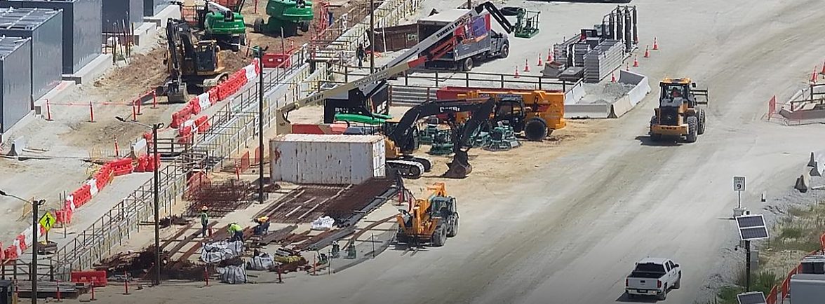 Aerial view of active construction operations with equipment and staging areas